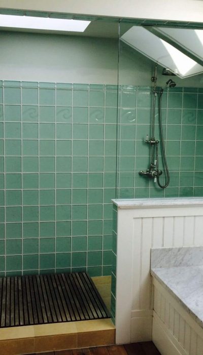 Green tiled shower enclosure in a background.